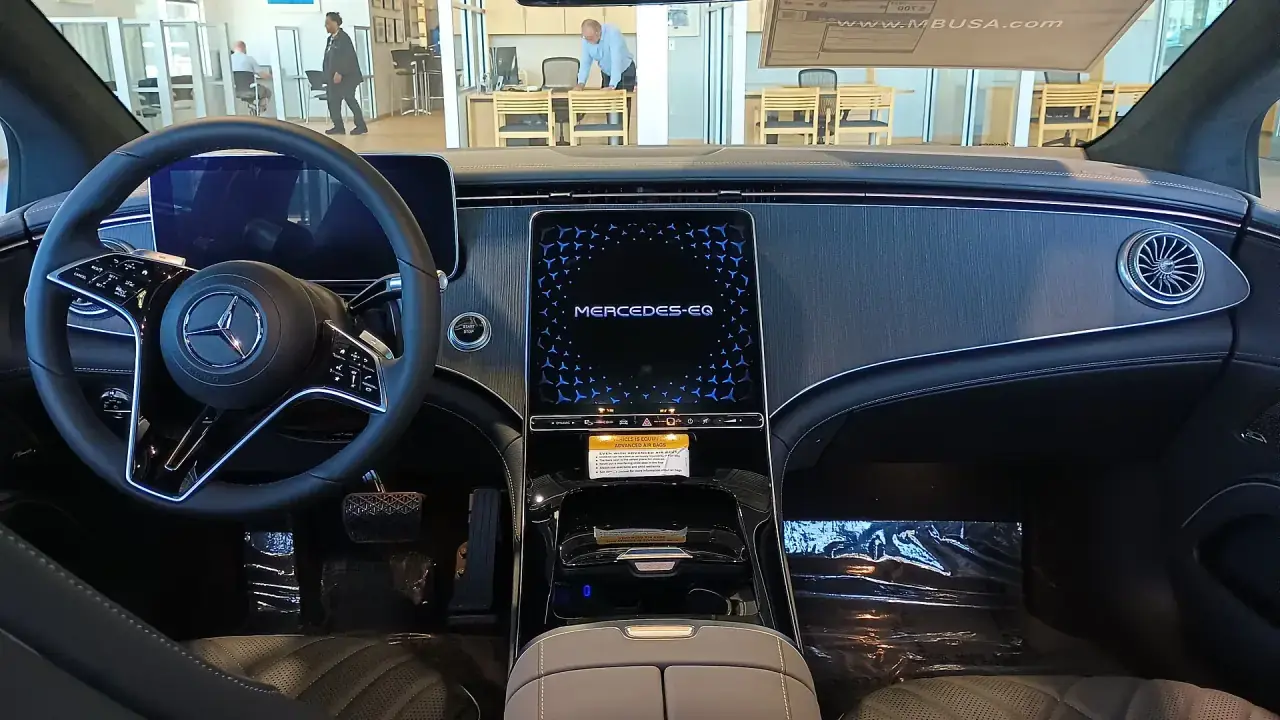 The minimal, screen-led cabin of a modern electrified saloon.